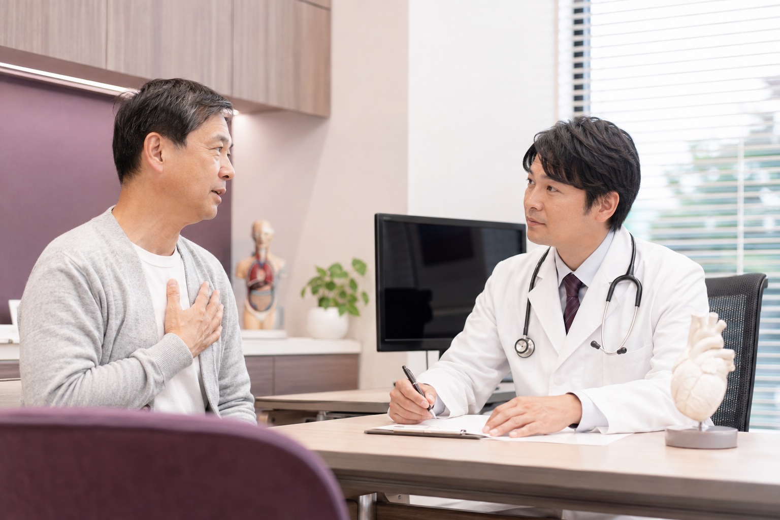 循環器内科医が患者から胸部症状の起こる状況を丁寧に聞いている診察場面
